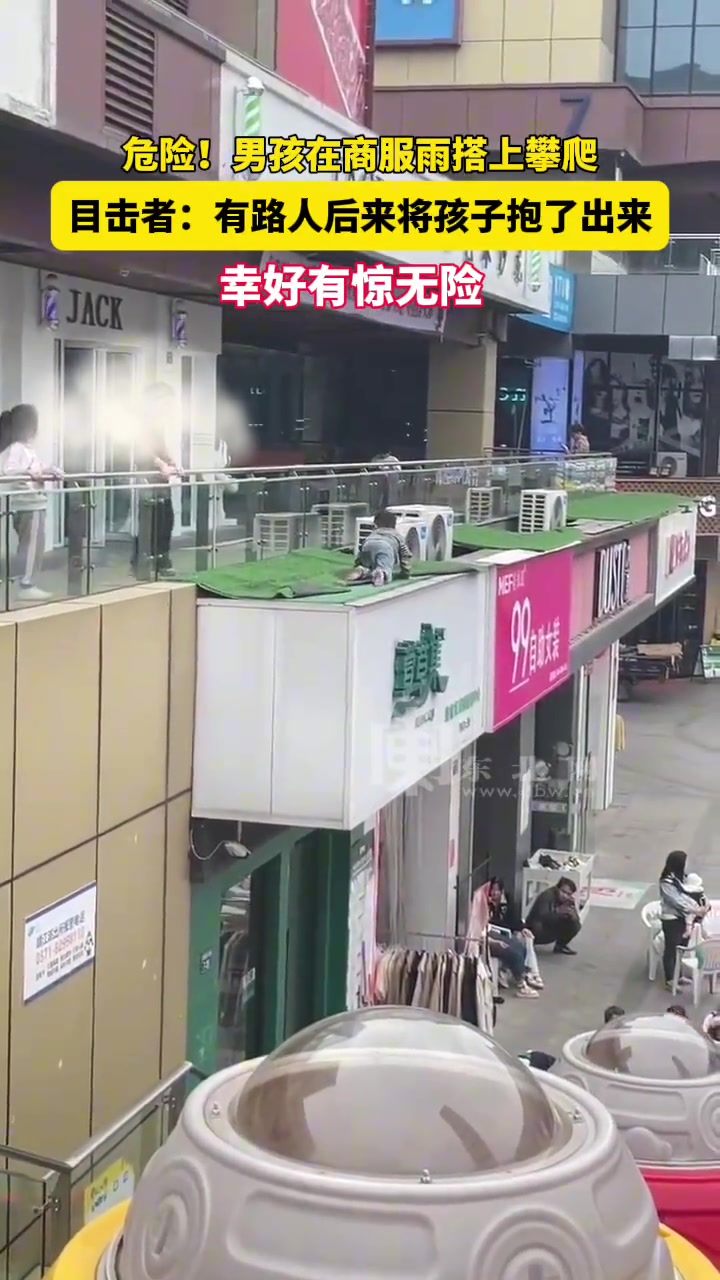 危险！男孩在商服雨搭上攀爬