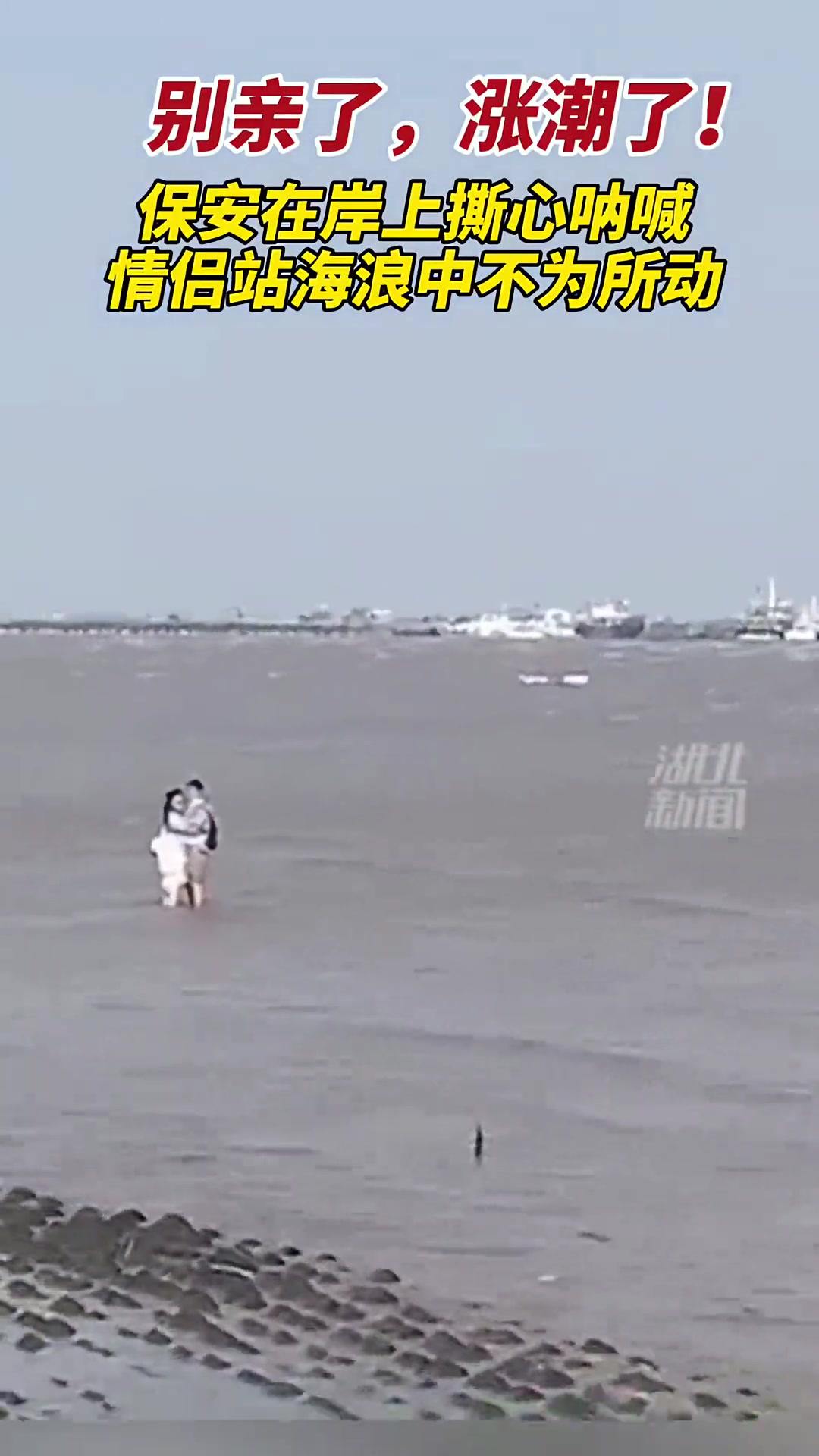 海滩突然涨潮情侣还在水中热吻 面对保安大喊不为所动
