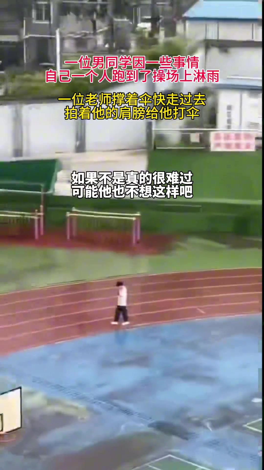 男生独自走在操场淋雨 老师快走过去为他撑伞