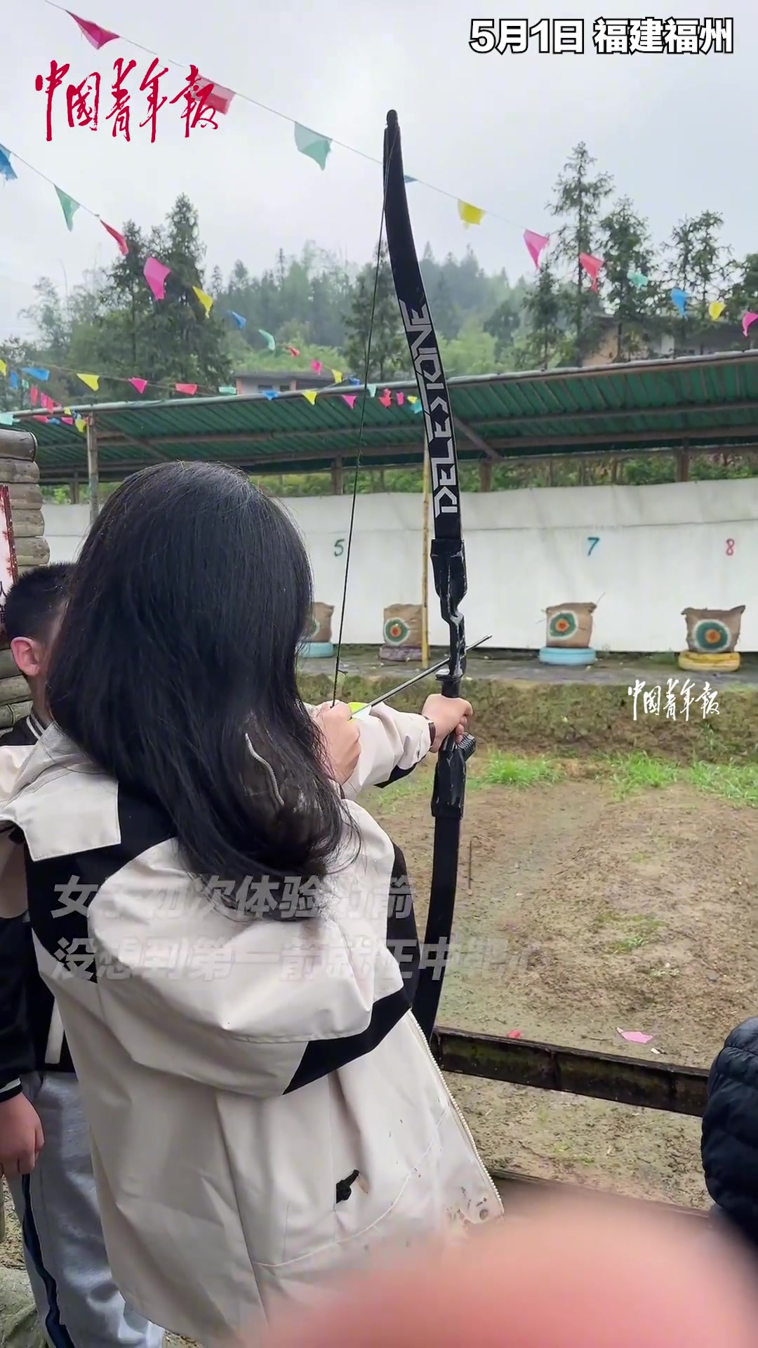女子初次体验射箭，第一箭就正中靶心。