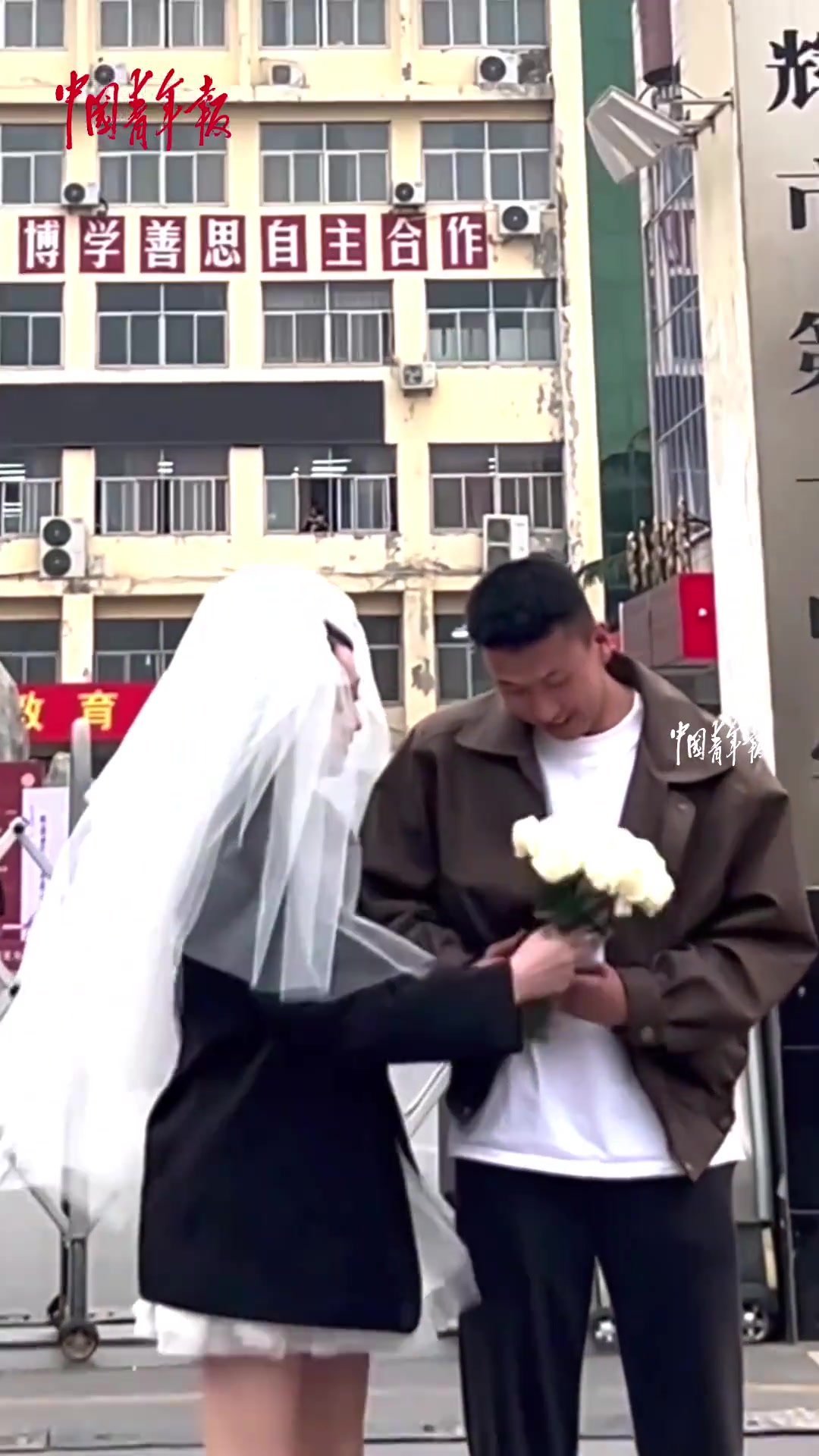 女孩和男友领证后，到曾经一起就读的中学合影纪念青春
