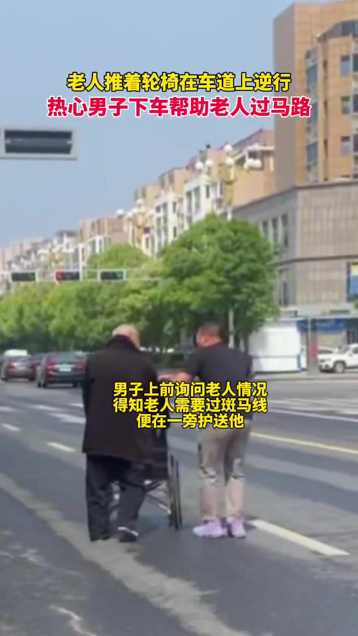 老人推着轮椅在车道上逆行，男子上前提供帮助