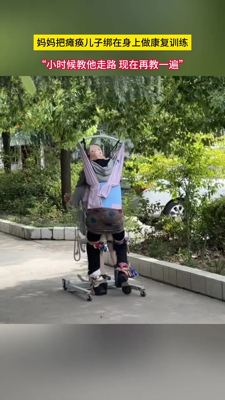 一位母亲将瘫痪儿子绑在身上，亲力亲为帮他做康复训练