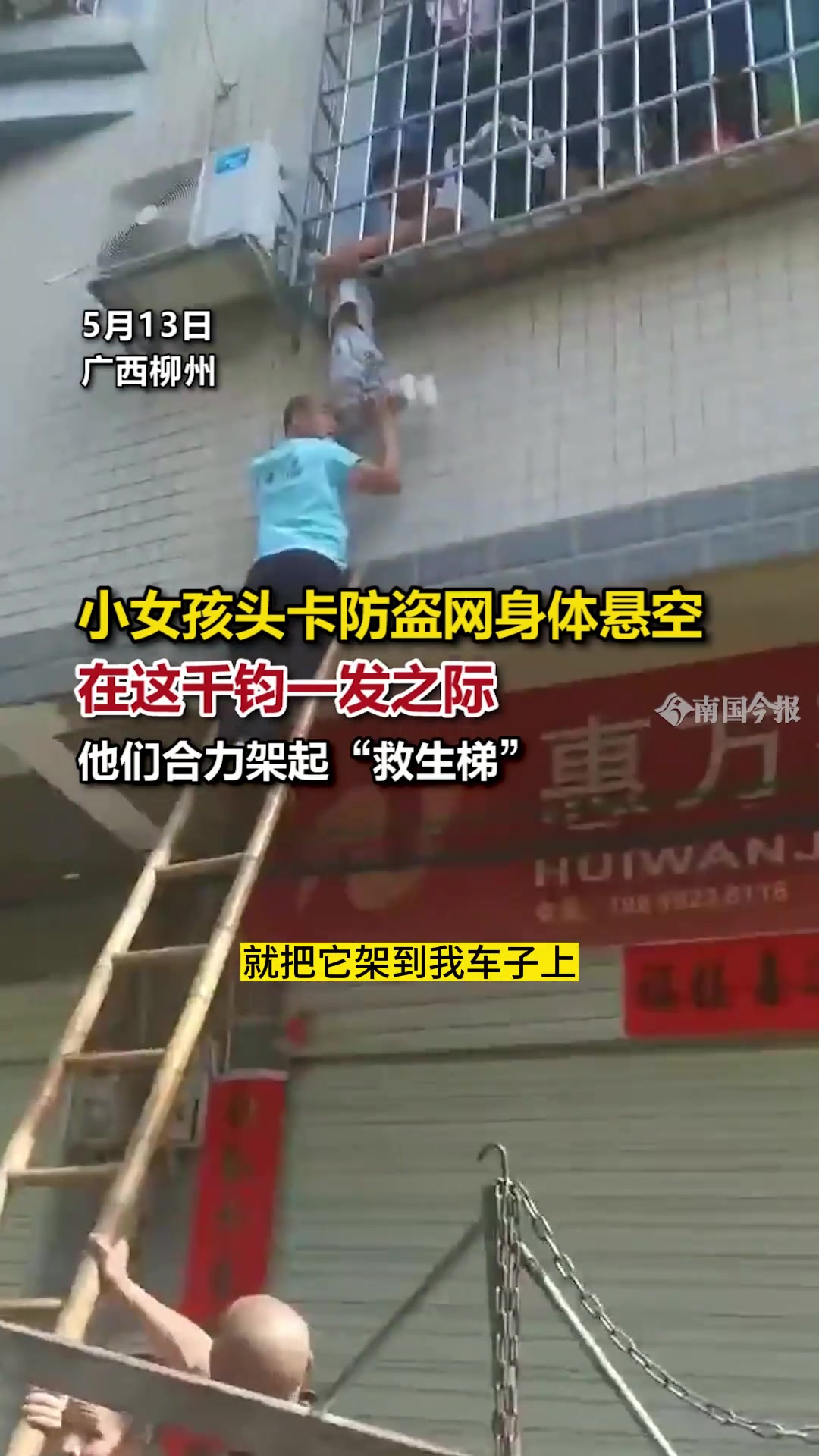 小女孩头卡防盗网身体悬空 众人合力架起“救生梯”