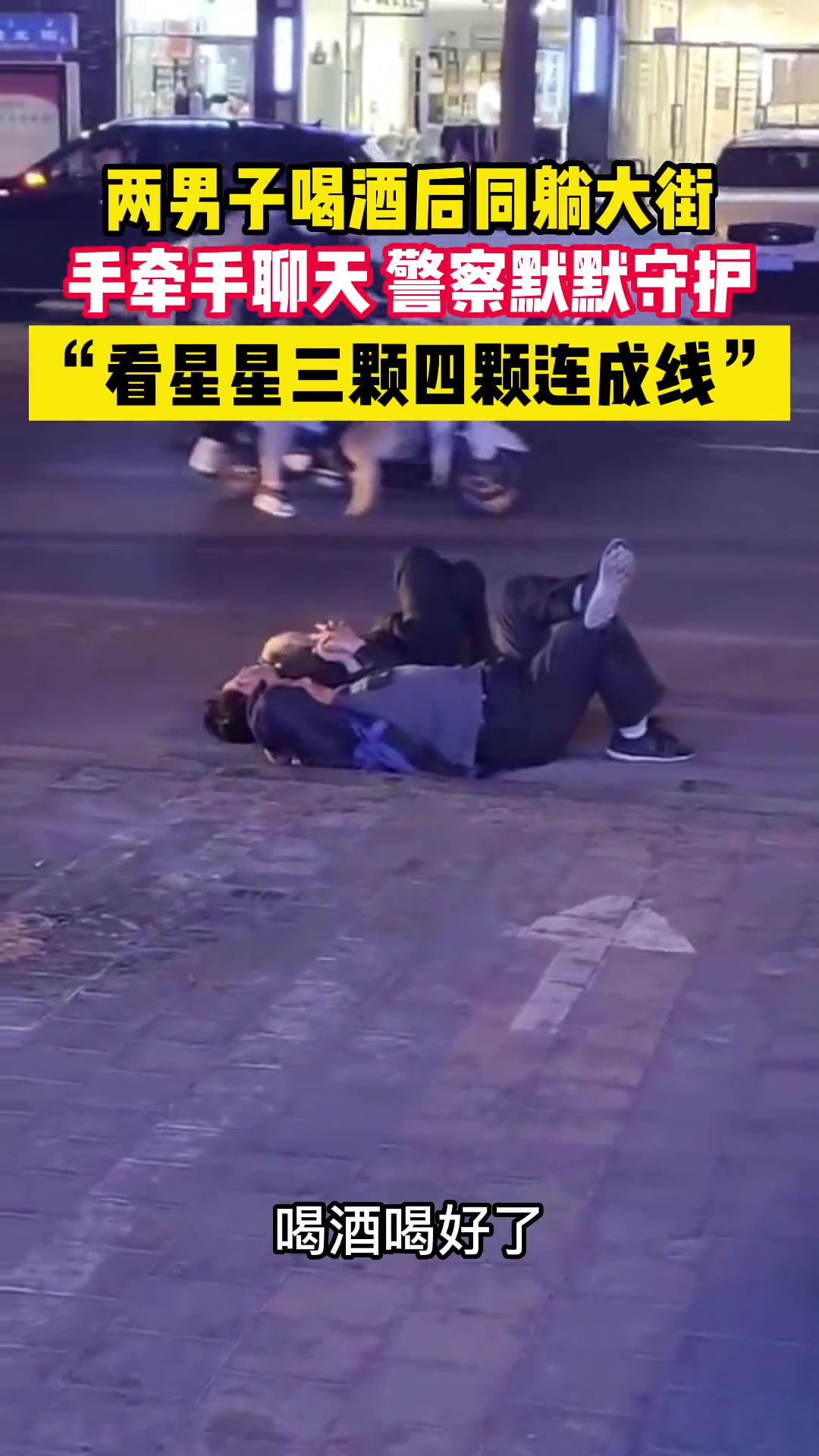 两男子喝酒后躺在街上手牵手聊天 警察在一旁默默守护