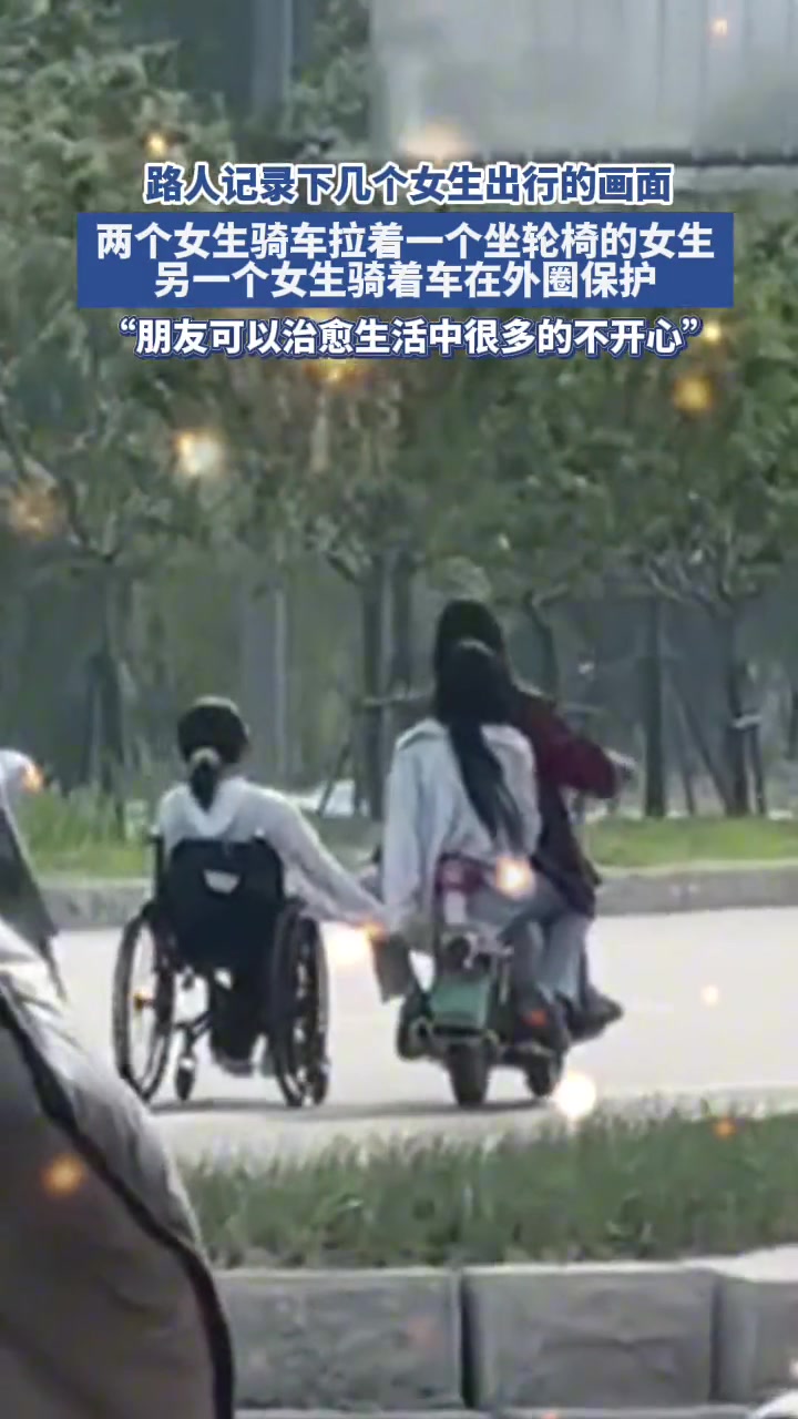 两个女生骑车拉着轮椅女生 另一个女生骑着车外圈保护