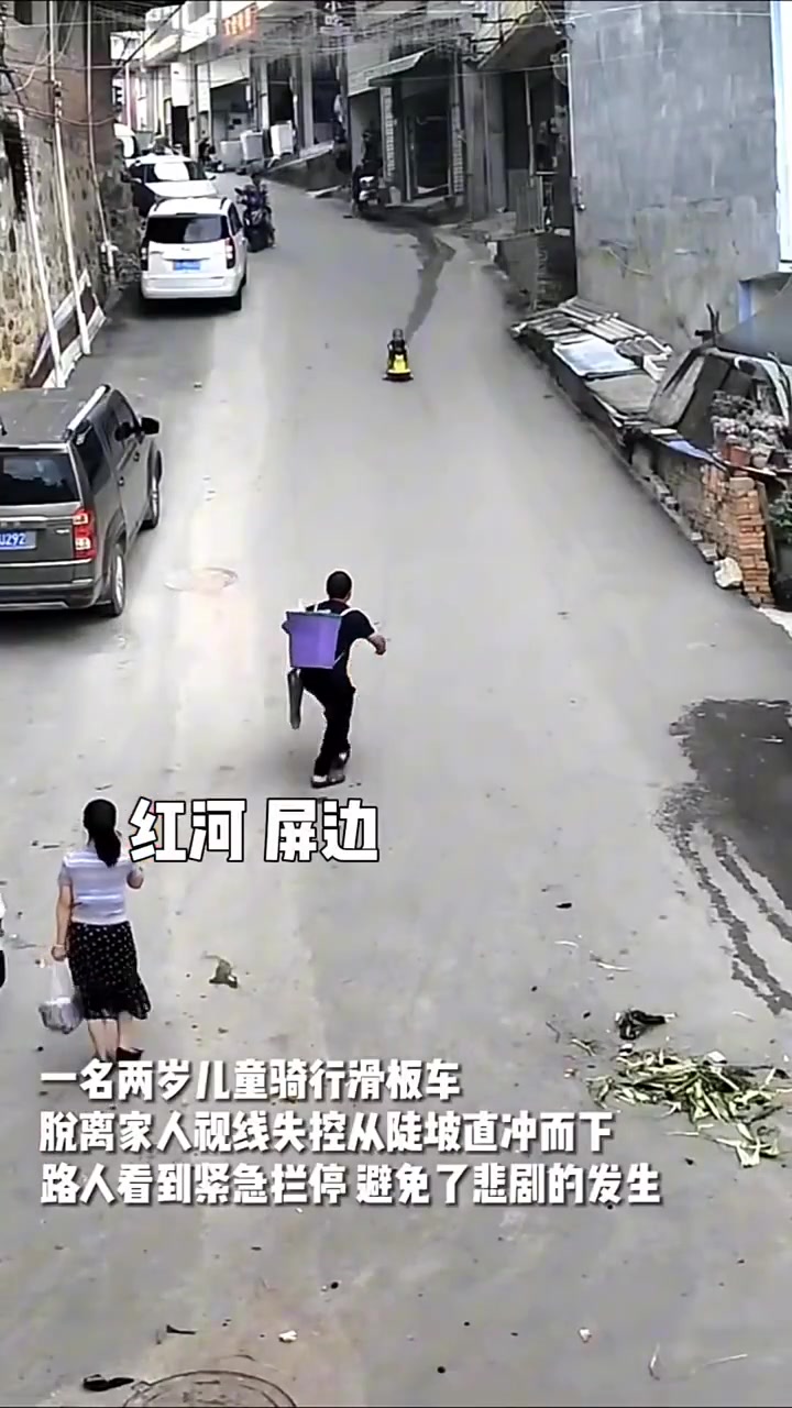 2岁儿童骑行滑板车从坡上冲下，大哥奋不顾身将其拦下