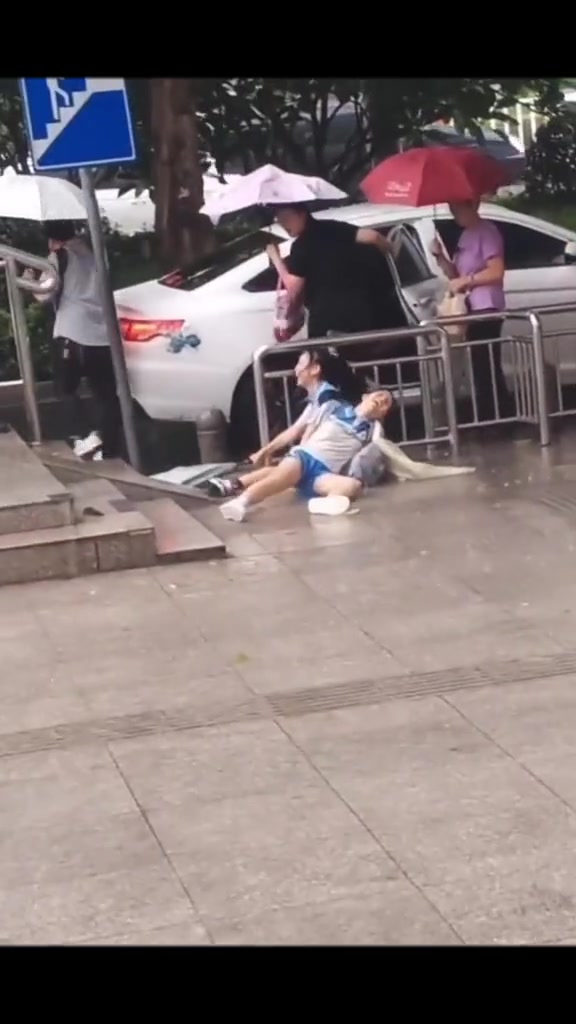 雨天俩女孩下楼梯时滑倒 但是他们笑的真开心
