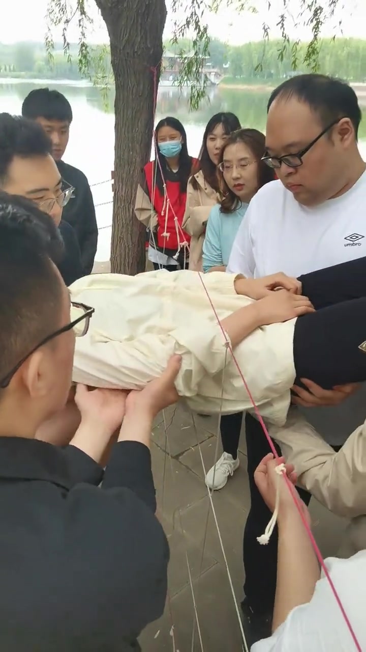 什么团建活动，这么多男的传递一个妹子？