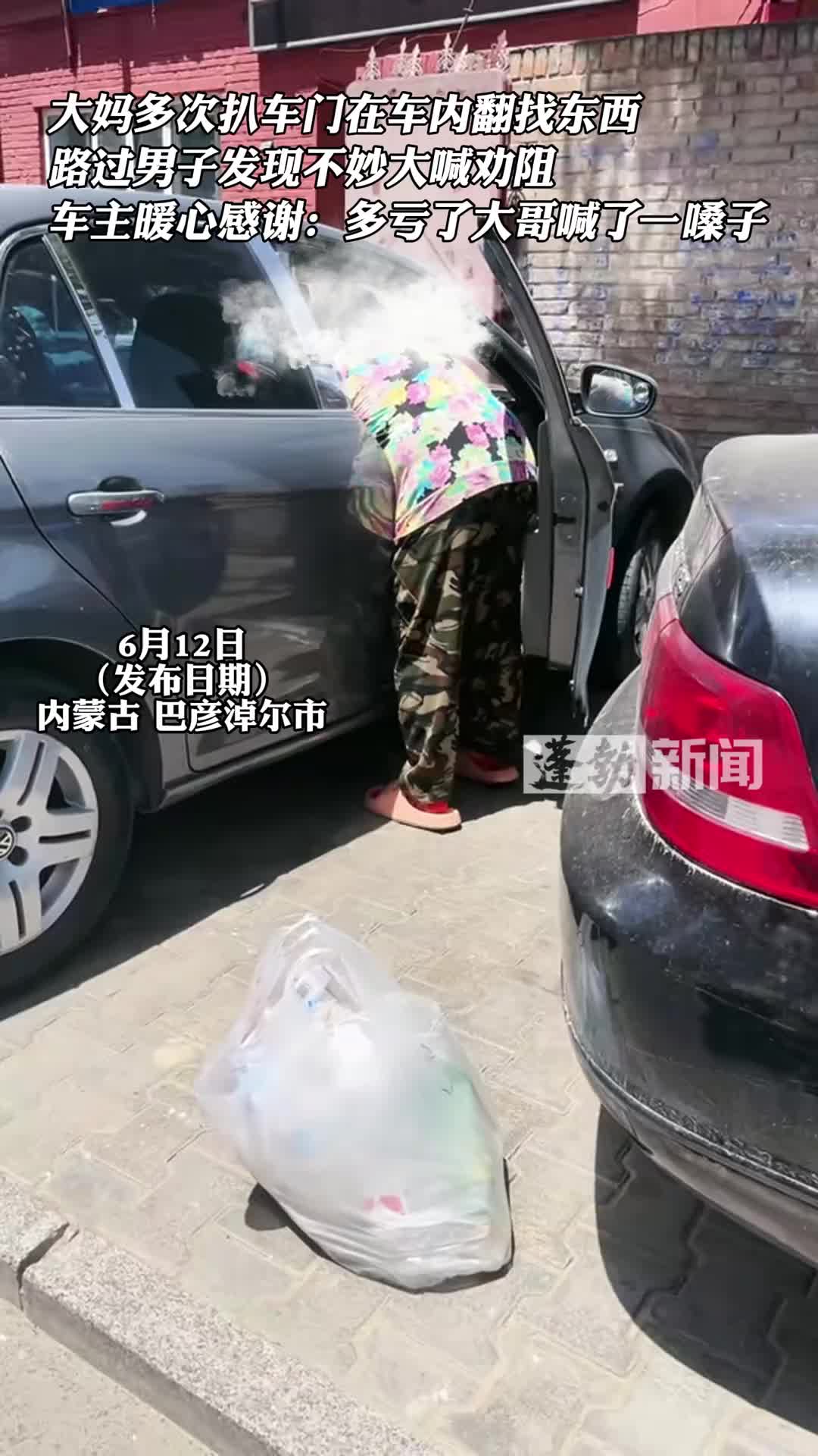 大妈扒车门在车内翻东西 路过男子发现不妙大喊劝阻